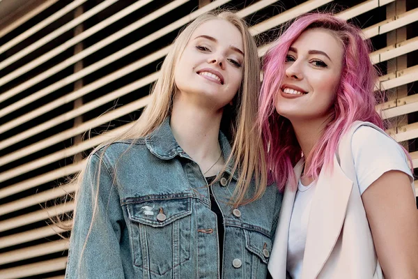 Şehirde takılmak süre kucaklayan hipster Genç Yetişkin arkadaşlar. İki genç kadın gülüyor ve kaygısız tatil yaşam tarzı zevk yürüyüş