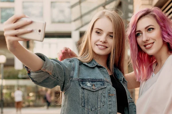 スマート フォンで Selfie を撮影し 顔と楽しいお友達 面白い顔を作ると Selfie の笑顔の女の子のクローズ アップ 都市の彼らのスマート — ストック写真