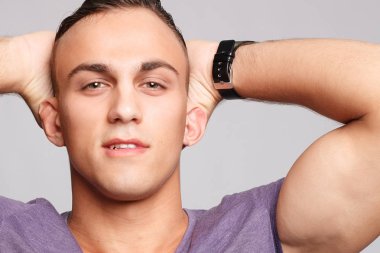 duygu, reklam ve insanlar kavramı - yakışıklı genç adam kameraya bakarak gri arka plan üzerinde. Seksi bir adam portresi. Mutlu erkek gülümseyen.