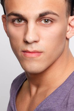 duygu, reklam ve insanlar kavramı - yakışıklı genç adam kameraya bakarak gri arka plan üzerinde. Seksi bir adam portresi. Mutlu erkek gülümseyen.