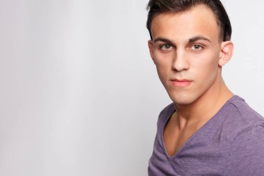 duygu, reklam ve insanlar kavramı - yakışıklı genç adam kameraya bakarak gri arka plan üzerinde. Seksi bir adam portresi. Mutlu erkek gülümseyen.
