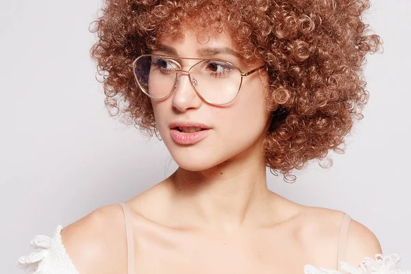 Gülümseyen genç siyah kadın portresi. Afro-Amerikan afro saç kesimi ve sihir makyaj ile güzel bir genç kadın portresi. Stüdyo vurdu. Çekici kız gözlük takıyor.
