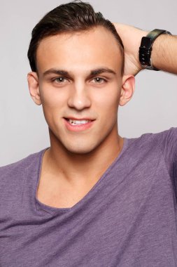 duygu, reklam ve insanlar kavramı - yakışıklı genç adam kameraya bakarak gri arka plan üzerinde. Seksi bir adam portresi. Mutlu erkek gülümseyen.