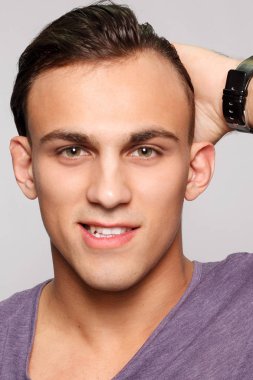 duygu, reklam ve insanlar kavramı - yakışıklı genç adam kameraya bakarak gri arka plan üzerinde. Seksi bir adam portresi. Mutlu erkek gülümseyen.