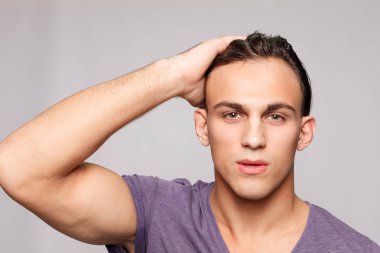 duygu, reklam ve insanlar kavramı - yakışıklı genç adam kameraya bakarak gri arka plan üzerinde. Seksi bir adam portresi. Mutlu erkek gülümseyen.