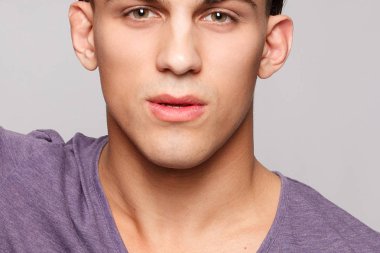 duygu, reklam ve insanlar kavramı - yakışıklı genç adam kameraya bakarak gri arka plan üzerinde. Seksi bir adam portresi. Mutlu erkek gülümseyen.