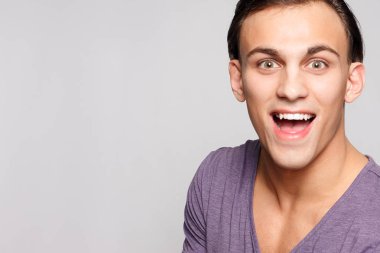 duygu, reklam ve insanlar kavramı - yakışıklı genç adam kameraya bakarak gri arka plan üzerinde. Seksi bir adam portresi. Mutlu erkek gülümseyen.