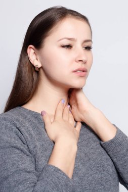 Hastalık, sağlık, insan, tıp kavramı - boğaz ağrısı. Closeup boğaz duygu kötü, ağrılı yutma acı ile hasta bir kadın. Güzel kız boyun el ile dokunmak