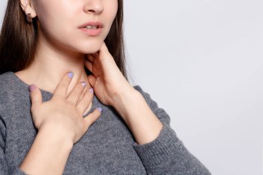 Hastalık, sağlık, insan, tıp kavramı - boğaz ağrısı. Closeup boğaz duygu kötü, ağrılı yutma acı ile hasta bir kadın. Güzel kız boyun el ile dokunmak