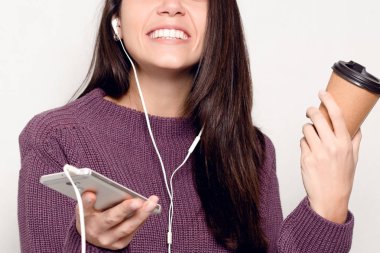 teknoloji, yaşam tarzı, internet bağımlılığı ve insanlar kavramı - akıllı telefon olan güzel kadın. Mutlu ve gülümseyerek çekici kadın cep telefonu arıyorum. Arka plan gri duvara.