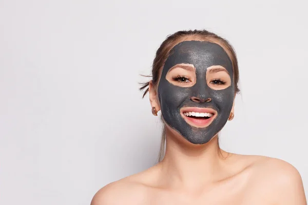 Woman Face Mask. Portrait Of Beautiful Girl Removing Cosmetic Black Peeling Mask From Facial Skin. Closeup Of Attractive Young Woman With Natural Makeup And Cosmetic Peel Mask On Face. High Resolution