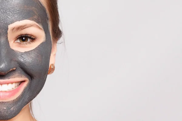 Woman Face Mask. Portrait Of Beautiful Girl Removing Cosmetic Black Peeling Mask From Facial Skin. Closeup Of Attractive Young Woman With Natural Makeup And Cosmetic Peel Mask On Face. High Resolution