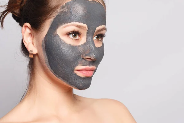 Woman Face Mask. Portrait Of Beautiful Girl Removing Cosmetic Black Peeling Mask From Facial Skin. Closeup Of Attractive Young Woman With Natural Makeup And Cosmetic Peel Mask On Face. High Resolution