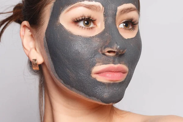 Woman Face Mask. Portrait Of Beautiful Girl Removing Cosmetic Black Peeling Mask From Facial Skin. Closeup Of Attractive Young Woman With Natural Makeup And Cosmetic Peel Mask On Face. High Resolution