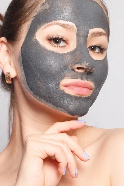 Woman Face Mask. Portrait Of Beautiful Girl Removing Cosmetic Black Peeling Mask From Facial Skin. Closeup Of Attractive Young Woman With Natural Makeup And Cosmetic Peel Mask On Face. High Resolution