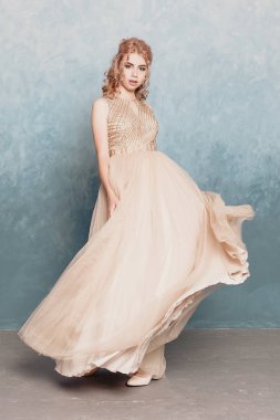 Şifon elbise, uzun uçan Abiye elbise, çarpıcı fantezi modeli ile kadında akan güzel lüks bej moda modeli. İpek kumaş üzerinde rüzgar sallıyor. Saten kumaş akan, dalgalar bir elbise