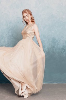Şifon elbise, uzun uçan Abiye elbise, çarpıcı fantezi modeli ile kadında akan güzel lüks bej moda modeli. İpek kumaş üzerinde rüzgar sallıyor. Saten kumaş akan, dalgalar bir elbise