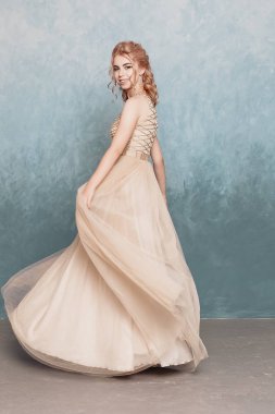 Şifon elbise, uzun uçan Abiye elbise, çarpıcı fantezi modeli ile kadında akan güzel lüks bej moda modeli. İpek kumaş üzerinde rüzgar sallıyor. Saten kumaş akan, dalgalar bir elbise