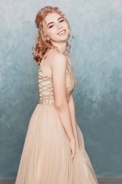 Şifon elbise, uzun uçan Abiye elbise, çarpıcı fantezi modeli ile kadında akan güzel lüks bej moda modeli. İpek kumaş üzerinde rüzgar sallıyor. Saten kumaş akan, dalgalar bir elbise