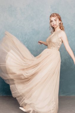 Şifon elbise, uzun uçan Abiye elbise, çarpıcı fantezi modeli ile kadında akan güzel lüks bej moda modeli. İpek kumaş üzerinde rüzgar sallıyor. Saten kumaş akan, dalgalar bir elbise