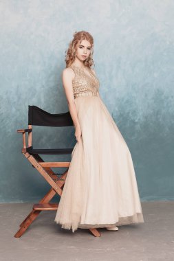 Şifon elbise, uzun uçan Abiye elbise, çarpıcı fantezi modeli ile kadında akan güzel lüks bej moda modeli. İpek kumaş üzerinde rüzgar sallıyor. Saten kumaş akan, dalgalar bir elbise