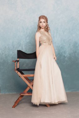 Şifon elbise, uzun uçan Abiye elbise, çarpıcı fantezi modeli ile kadında akan güzel lüks bej moda modeli. İpek kumaş üzerinde rüzgar sallıyor. Saten kumaş akan, dalgalar bir elbise