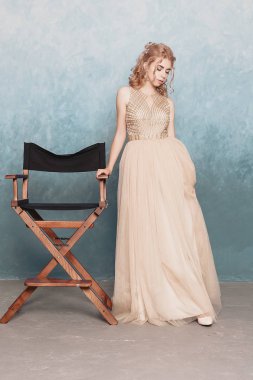 Şifon elbise, uzun uçan Abiye elbise, çarpıcı fantezi modeli ile kadında akan güzel lüks bej moda modeli. İpek kumaş üzerinde rüzgar sallıyor. Saten kumaş akan, dalgalar bir elbise