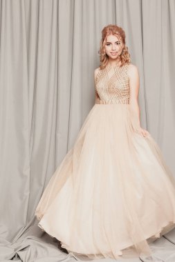 Şifon elbise, uzun uçan Abiye elbise, çarpıcı fantezi modeli ile kadında akan güzel lüks bej moda modeli. İpek kumaş üzerinde rüzgar sallıyor. Saten kumaş akan, dalgalar bir elbise