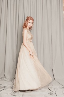 Şifon elbise, uzun uçan Abiye elbise, çarpıcı fantezi modeli ile kadında akan güzel lüks bej moda modeli. İpek kumaş üzerinde rüzgar sallıyor. Saten kumaş akan, dalgalar bir elbise