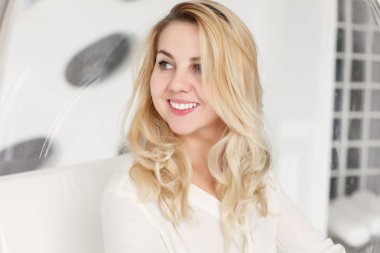 duygular, ifadeler, saç modeli ve insanlar kavramı - genç kadın veya genç kız onun saç teli tutan gülümseyerek. sarışın kız gülümseyerek