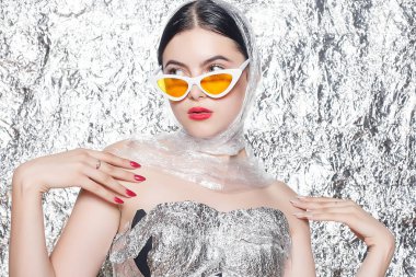 Gümüş arka plan üzerinde siyah bir elbise genç güzel kız. Sanat fantezi makyaj sanatsal kadınla tarz. Vogue tarzı. Yaratıcılık. Moda kız. Güzellik kadın portre. Yüz yakın çekim. Manikürlü tırnaklar.