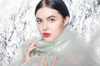 Gümüş arka plan üzerinde siyah bir elbise genç güzel kız. Sanat fantezi makyaj sanatsal kadınla tarz. Vogue tarzı. Yaratıcılık. Moda kız. Güzellik kadın portre. Yüz yakın çekim. Manikürlü tırnaklar.