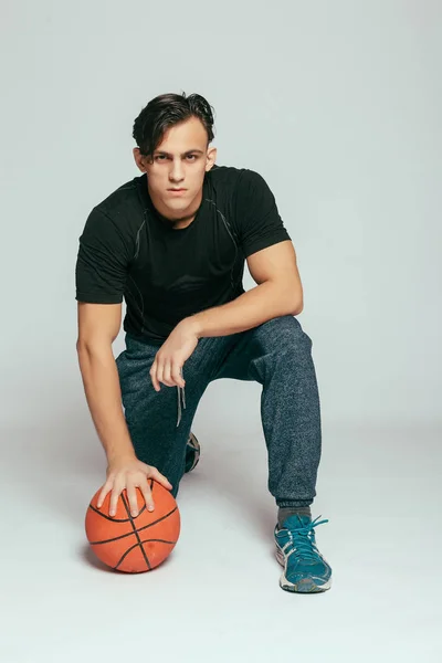 体育和生活方式概念 真正的球员 英俊的年轻微笑的男子背着一个篮球球 看着相机 而站在反对灰色背景 — 图库照片