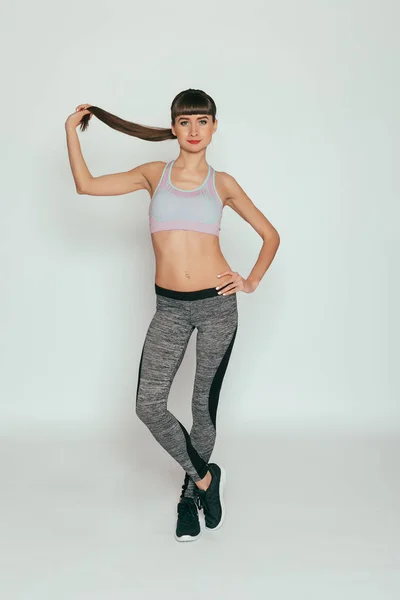 体育和生活方式概念 年轻快乐健身女孩与运动身体在演播室在灰色背景 漂亮合身的女孩 灰色运动服的健身模式 健康的生活方式 — 图库照片