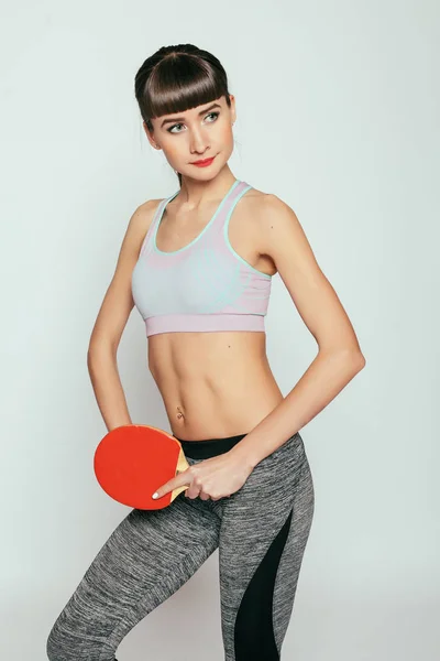 体育和生活方式概念 年轻妇女拿着乒乓球球拍和球 年轻快乐健身女孩与运动的身体在工作室灰色背景 — 图库照片