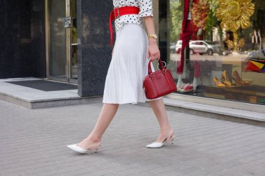 siyah lekeli beyaz elbise giyen güzel model bak esmer bir şehir sokak arka planda şık çanta el ile uyanma sırasında kadındır.