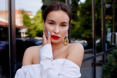 Esmer beyaz gömlek ve mavi pantolon giyiyor. İş kıyafeti. Casual bak. Vitrin yanında duruyor. Tüm vücut bak.