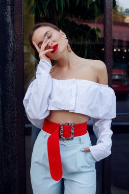 Esmer beyaz gömlek ve mavi pantolon giyiyor. İş kıyafeti. Casual bak. Vitrin yanında duruyor. Tüm vücut bak.