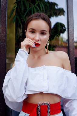 Esmer beyaz gömlek ve mavi pantolon giyiyor. İş kıyafeti. Casual bak. Vitrin yanında duruyor. Tüm vücut bak.