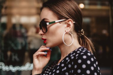 siyah lekeli beyaz elbise giyen güzel model bak esmer bir şehir sokak arka planda şık çanta el ile uyanma sırasında kadındır.