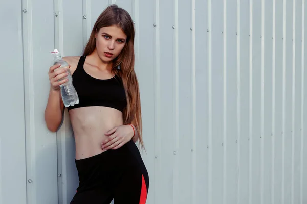 Sportlerin Trinkt Wasser Während Sie Einer Grauen Wand Steht Schlanke — Stockfoto