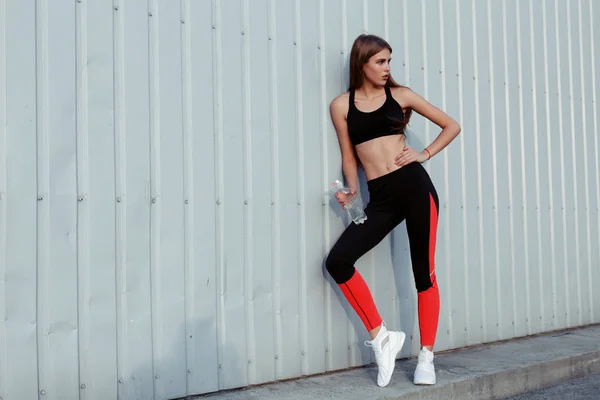 Atleta Bebiendo Agua Mientras Está Parada Junto Una Pared Gris — Foto de Stock