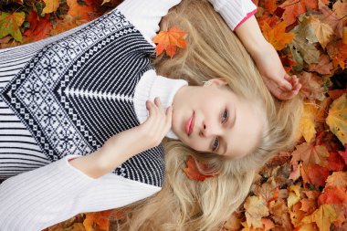 Güzellik, insanlar, sezon ve sağlık kavramı - kırmızı sonbahar yaprakları sarı renk ile güzel kız yalan söylüyor