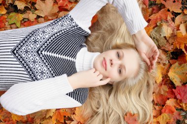 Güzellik, insanlar, sezon ve sağlık kavramı - kırmızı sonbahar yaprakları sarı renk ile güzel kız yalan söylüyor