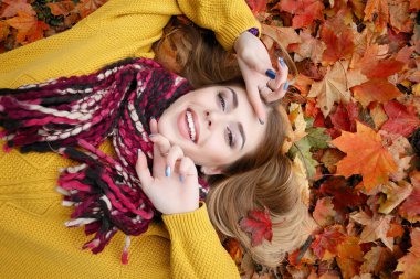 Güzellik, insanlar, sezon ve sağlık kavramı - kırmızı sonbahar yaprakları sarı renk ile güzel kız yalan söylüyor