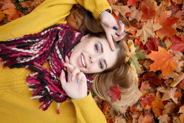 Güzellik, insanlar, sezon ve sağlık kavramı - kırmızı sonbahar yaprakları sarı renk ile güzel kız yalan söylüyor