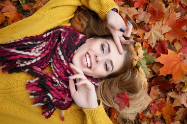 Güzellik, insanlar, sezon ve sağlık kavramı - kırmızı sonbahar yaprakları sarı renk ile güzel kız yalan söylüyor