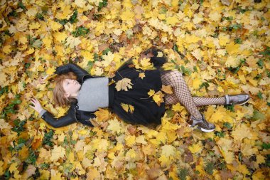 Güzellik, insanlar, sezon ve sağlık kavramı - sevimli küçük kız sarı sonbahar yaprak yalan söylüyor