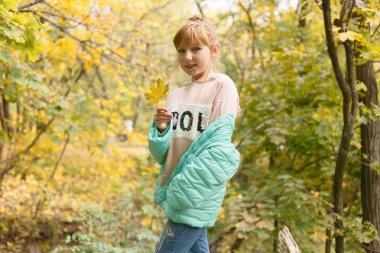 çocukluk, sezon ve insanlar kavramı - küçük kızla mutlu düşmüş akçaağaç sonbahar park adlı bırakır.