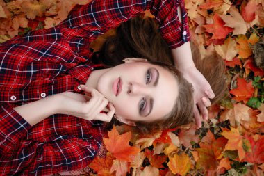 Güzellik, insanlar, sezon ve sağlık kavramı - kırmızı sonbahar yaprakları sarı renk ile güzel kız yalan söylüyor